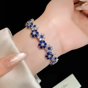 Close-up detail of an elegant blue and white zircon flower bracelet worn on a wrist