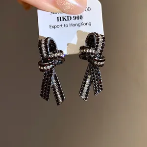 Primer plano de elegantes pendientes de nudo vintage con detalles de cristales rojos