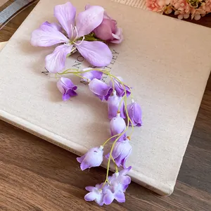 Detailed macro shot of a purple fabric flower hair clip with an elegant floral tassel.