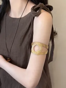 Detailed view of a vintage style gold spiral arm cuff worn on the upper arm of a model