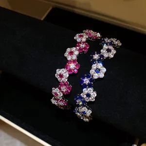 Macro detail of elegant interlocking zircon flower bracelets with sparkling pink and blue gemstones