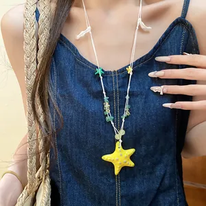 Primer plano de un collar de cuentas con estrella de mar colorida usado por una modelo.