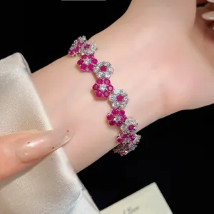 Detailed macro view of silver floral bracelet with red and white sparkling zircons
