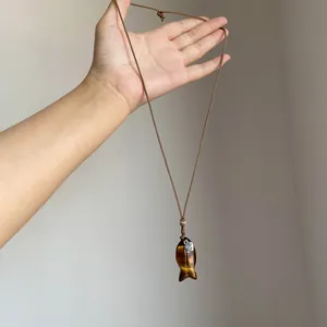 Detailansicht einer Retro-Fisch-Halskette mit Tigerauge-Stein und Herz-Anhänger
