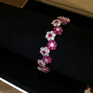 Close-up detail of an elegant flower bracelet featuring sparkling red and white zircons