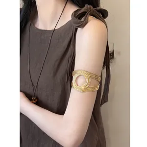 Detail view of a vintage style gold multi-layered spiral arm cuff on a model's arm