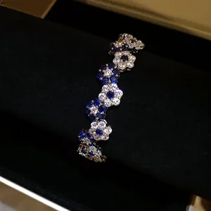 Close-up of an elegant flower bracelet with deep blue and sparkling clear zircons