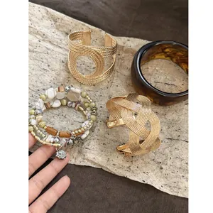 Detailed view of vintage Maillard resin bangle and woven gold cuff bracelet set