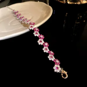 Detailed close-up of a silver bracelet featuring pink and white zircon flower clusters