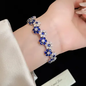 Close-up of elegant flower bracelet with blue and white zircons worn on the wrist