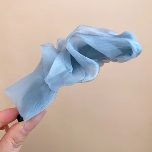 Detail view of the elegant blue organza ruffled fabric banana hair clip accessory.