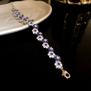 Close-up of elegant flower bracelet with sparkling blue and white cubic zirconia stones
