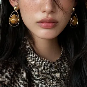 Vintage American style teardrop earrings with stone texture in a gold frame.