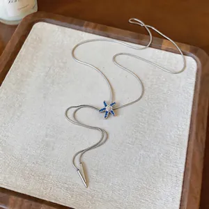 Detailed macro view of silver starfish tassel necklace with sparkling blue rhinestones