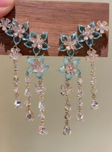 Detailed macro view of elegant blue zircon flower tassel earrings with golden finish