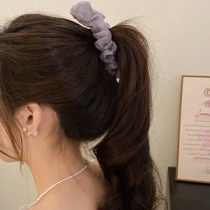 Detail view of a lavender pleated fabric banana clip elegantly styling a high ponytail.