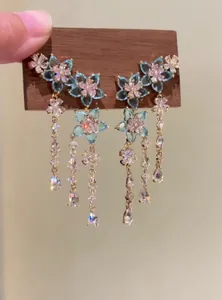 Detailed view of elegant blue zircon flower earrings with long shimmering tassels.