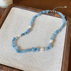 Detail of blue crushed stone necklace with elegant white pearls on a display tray.