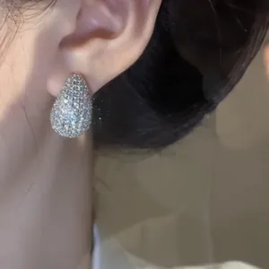 Close-up detail of elegant teardrop stud earrings paved with sparkling white cubic zirconia