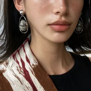 Close-up of model wearing vintage silver drop earrings with elegant marble stone