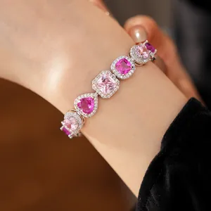 Detailed close-up showing elegant pink heart and square zircon bracelet worn on a female wrist