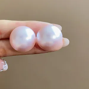 Primer plano de pendientes de perlas redondas rosas con un hermoso brillo iridiscente
