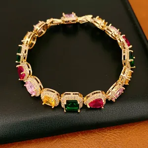 Close-up of elegant gold-plated bracelet with multi-colored oval and square zircons.