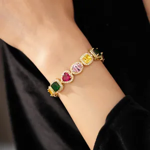 Detailed view of a luxury gold bracelet featuring colorful heart and oval zircon gemstones
