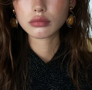 Macro detail view of vintage water drop earrings featuring amber resin in golden frames