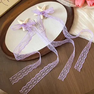 Dettaglio di mollette per capelli in pizzo viola con stelle marine e cuori