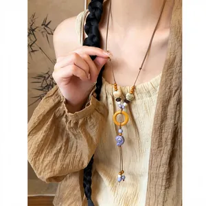 Detailed view of a handmade ethnic style necklace with ceramic shell and wood pendant