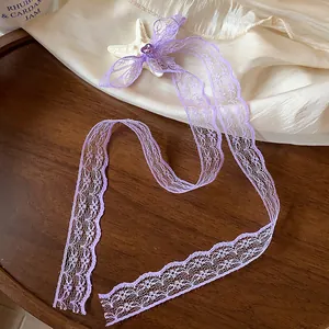 Dettaglio del fermaglio per capelli con fiocco in pizzo viola e stella marina