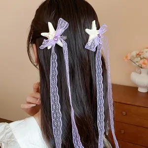 Dettaglio di una molletta per capelli a stella marina con fiocco in pizzo viola e nastri