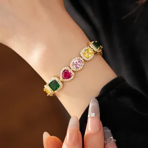 Detail shot of a luxury gold-plated bracelet with multi-colored heart and cushion zircons