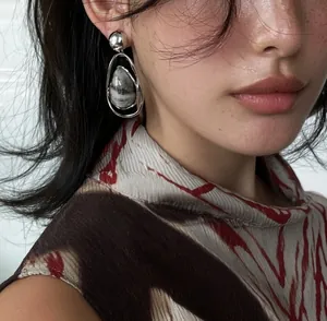 Detailed close-up of vintage silver drop earrings featuring a marbled stone pendant
