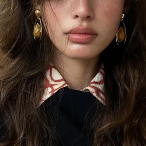 Close-up detail of vintage waterdrop earrings with amber stone texture on model