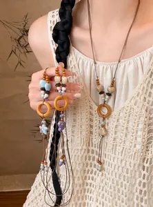 Detail view of an ethnic style necklace with wooden circles and ceramic shell charms