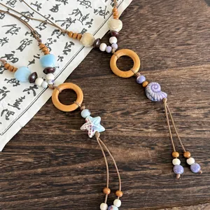 Detail of ethnic style necklace with ceramic starfish, shell, and wood elements