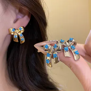 Detailed close-up view of elegant bow knot earrings featuring vibrant blue zircon flower petals