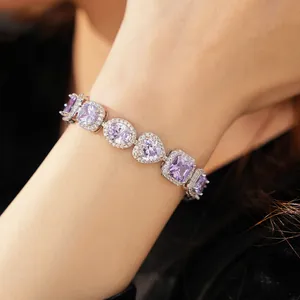 Macro view of a silver bracelet with heart and oval-shaped purple zircon stones.
