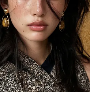 Detailed close-up of model wearing vintage water-drop earrings with marbled stone texture