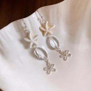 Elegant starfish and oval glass bead drop earrings with hollow flower charms on seashell