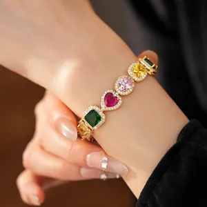 Detailed view of luxury gold bracelet with multi-color heart and oval zircons