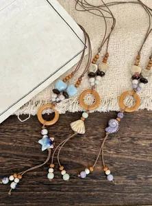 Close-up of ethnic necklaces with wooden rings, ceramic beads, and shell pendants