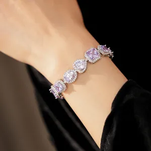 Close-up of elegant silver-tone bracelet with purple zircon heart and oval stones.