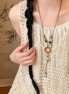 Detailed view of an ethnic style necklace with ceramic shell and wooden beads on a model.