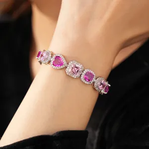 Close-up of elegant pink and purple heart-shaped zircon bracelet on woman's wrist detail
