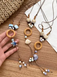 Detail view of handmade ethnic necklaces featuring wooden rings and unique shell pendants