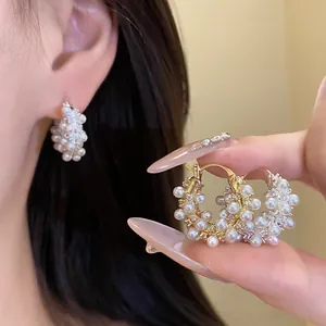Close-up of 18k gold plated hoop earrings featuring clustered pearls and zircon accents