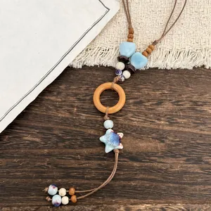 Detailed close-up of ethnic style necklace with blue ceramic stars and wooden rings